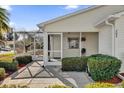 Front entry with covered porch and well-manicured landscaping at 202 Estrada Pl, The Villages, FL 32159
