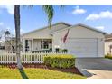 House exterior with white siding and a two-car garage at 202 Estrada Pl, The Villages, FL 32159