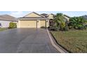 Two-story house with a three-car garage and palm trees at 2131 Baldwin Run, The Villages, FL 32162