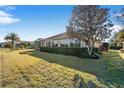 Back of house with a screened patio, landscaping, and large yard at 2131 Baldwin Run, The Villages, FL 32162