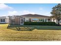 Back of house featuring a screened patio and lush landscaping at 2131 Baldwin Run, The Villages, FL 32162