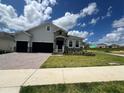 Beautiful single-Gathering home with a well-maintained lawn, two-car garage, and brick paved driveway at 2137 Sunshine Peak Dr, Minneola, FL 34715