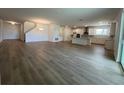 Spacious open-concept living room with modern flooring and a view of the kitchen at 2137 Sunshine Peak Dr, Minneola, FL 34715