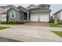Two-story house with gray siding, light-colored garage doors, and a paved driveway at 2252 Juniper Berry Dr, Minneola, FL 34715