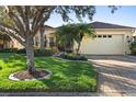 House with lush lawn, palm trees, and a brick driveway at 233 Monterey St, Kissimmee, FL 34759