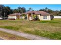 Single-story house with a two-car garage and landscaped yard at 305 W Lady Lake Blvd, Lady Lake, FL 32159