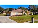 Spacious home with a circular driveway and lush lawn at 305 W Lady Lake Blvd, Lady Lake, FL 32159