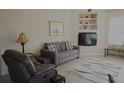 Living room with grey couch and built-in shelving at 5622 Sir Churchill Dr, Leesburg, FL 34748