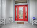 Inviting red front door with glass panels and a welcoming mat at 5626 Squires Dr, Leesburg, FL 34748