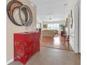 Bright and airy entryway with red Asian-style cabinet and view of living room at 906 Drakeswood Ave, The Villages, FL 32162