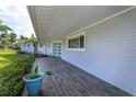 Gray-toned modern front porch with teal door and wood-like tile at 100 Via Capri, New Smyrna Beach, FL 32169