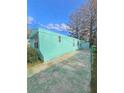 Side view of a teal mobile home showcasing its length and yard space at 1005 Oakland St. St, Tavares, FL 32778