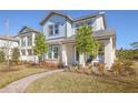 Two-story light blue house with gray accents, landscaping, and walkway at 10093 Pearson Ave, Orlando, FL 32827