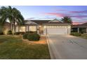 Well-maintained single story home with a two car garage, beautifully lit at dusk at 1149 Eureka Mill Run, The Villages, FL 32162