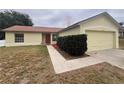 House exterior featuring a landscaped walkway and attached garage at 11550 Foxglove Dr, Clermont, FL 34711