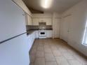 Galley-style kitchen with white cabinets and tile flooring at 11550 Foxglove Dr, Clermont, FL 34711