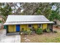 Small yellow house with a metal roof and small yard at 1319 Stowe Ave, Mount Dora, FL 32757