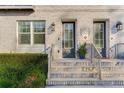 Two townhome entrances featuring gray doors, brick facade, and a shared staircase at 133 S Park Ave, Winter Garden, FL 34787