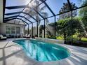 Relaxing kidney-shaped pool with screened enclosure at 1369 Harley Cir, The Villages, FL 32162