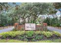 Welcoming community entrance with brick signage, mature trees, and landscaped grounds at 1701 Cedar Stone Ct, Lake Mary, FL 32746