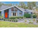 Charming home featuring a brightly colored front door, lush landscaping, and a modern design at 1701 Cedar Stone Ct, Lake Mary, FL 32746