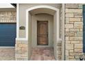 Elegant wood front door with stone entryway at 17889 Gourd Neck Loop, Winter Garden, FL 34787