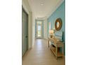 Inviting foyer with a decorative mirror, stylish console table, and serene blue accent wall at 2022 Wallingford Loop, Mount Dora, FL 32757