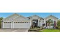 Three-car garage, mature landscaping, inviting front entrance at 2054 Vision Ct, The Villages, FL 32163