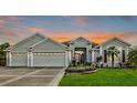 Beautiful home with three-car garage, landscaping, and sunset view at 2054 Vision Ct, The Villages, FL 32163