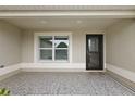 Covered entryway with a window and a decorative door at 2080 Nordic Ln, The Villages, FL 32163