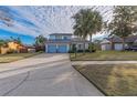 Front view of a two-story house with a light blue garage door at 2355 Lakeview Ave, Clermont, FL 34711