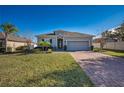 Curb appeal abounds at this one-story home with gray siding and paver driveway at 24506 Woodhill Ct, Sorrento, FL 32776