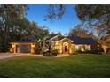 Well lit home at night with lush landscaping at 2614 W Ponkan Rd, Apopka, FL 32712