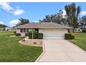 Front view of a single-story house with a two-car garage at 26409 Evert St, Leesburg, FL 34748