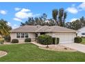 Landscaped yard surrounds this single-story house with a garage at 26409 Evert St, Leesburg, FL 34748