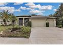 Single-story house with a three-car garage, palm trees, and well-maintained landscaping at 27238 Stoney Brook Dr, Leesburg, FL 34748