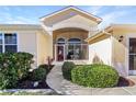 Inviting entryway with red door and nicely landscaped walkway at 27527 Briar Patch Pl, Leesburg, FL 34748