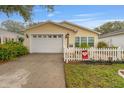 Charming home exterior with two-car garage, flower beds, and a white picket fence at 2821 Barboza Dr, The Villages, FL 32162