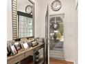 Bright entryway with a console table displaying Gathering photos and a mirrored accent wall at 36703 Sandy Ln, Grand Island, FL 32735