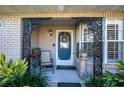 Charming covered entryway with a decorative wrought iron arch and beautiful blue front door at 36703 Sandy Ln, Grand Island, FL 32735