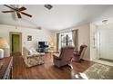 Living room with hardwood floors, comfy seating, and a large window at 401 Cherry Tree St, Eustis, FL 32726