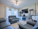 Living room with gray couches and a large TV at 5929 Coquyt Dr, Mount Dora, FL 32757