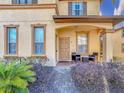 Townhome entry with brick walkway and porch seating at 647 Calabria Ave, Davenport, FL 33897