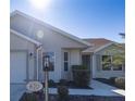 Front view of tan house with walkway and landscaping at 670 Murphys Estate Dr, The Villages, FL 32162