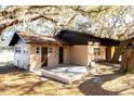 House exterior showcasing a tan brick facade, brown roof and carport at 73 N Carol Ave, Mascotte, FL 34753