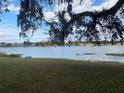 Serene lakefront view with lush green grass and a kayak at 73 N Carol Ave, Mascotte, FL 34753