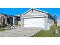 Gray house with white garage door, landscaping, and a walkway leading to the entrance at 808 Brooklet Dr, Davenport, FL 33837