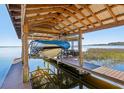 Covered boat lift on a private dock, perfect for enjoying lake life at 9724 Rosemary Ln, Leesburg, FL 34788