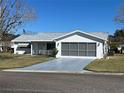 This single-story home features a screened garage, painted driveway, and manicured lawn at 10173 Se 175Th Ln, Summerfield, FL 34491