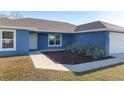 Blue house exterior with a walkway and landscaping at 105 Juniper Run, Ocala, FL 34480